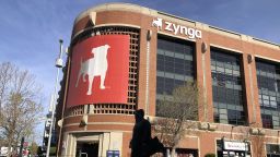 A pedestrian walks in front of a sign at Zynga in San Francisco, Tuesday, March 16, 2021. Take-Two Interactive, maker of Grand Theft Auto and Red Dead Redemption, is buying Zynga, maker of FarmVille and Words With Friends, in a cash-and-stock deal with an enterprise value of about $12.7 billion. Take-Two said Monday, Jan. 10, 2022, it anticipates $100 million in annual cost savings.