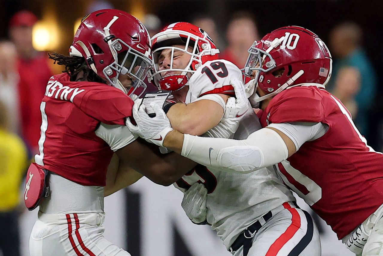 Bowers is tackled by Kool-Aid McKinstry, left, and Henry To'oTo'o during the first half. The opening 30 minutes were a defensive struggle between the two teams, and Alabama led 9-6 at halftime.