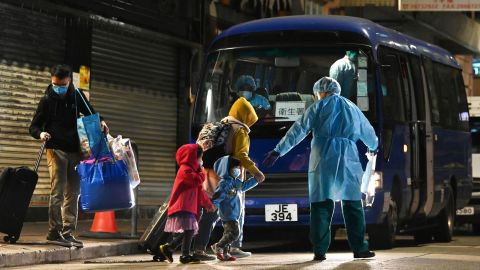 A worker in a protective suit helps bring residents to quarantine after new cases were reported on January 9 in Hong Kong.