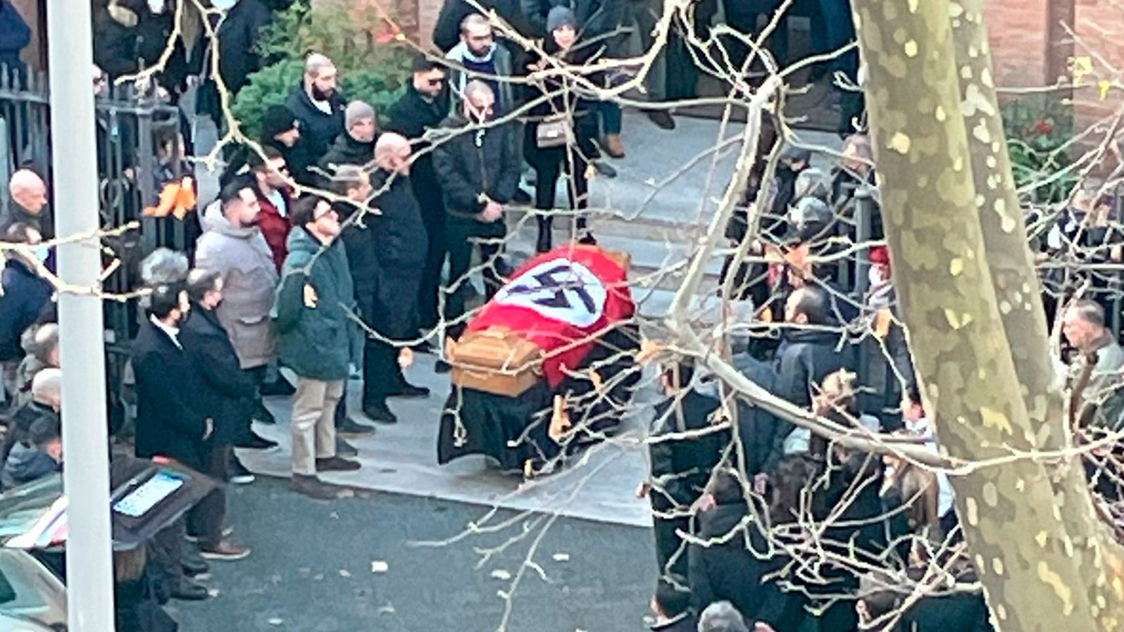 A picture made available by the Italian online news portal Open shows people gathered around a swastika-covered casket outside the St. Lucia church in Rome, Italy, on Monday.