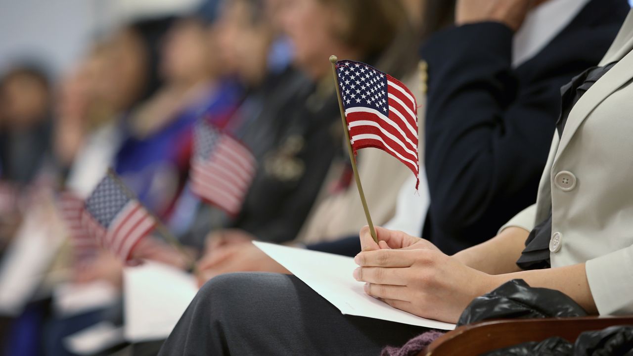 Immigrants hold flags while waiting for a naturalization ceremony to become U.S. citizens at the district office of U.S. Citizenship and Immigration Services (USCIS) on January 28, 2013 in Newark, New Jersey. 