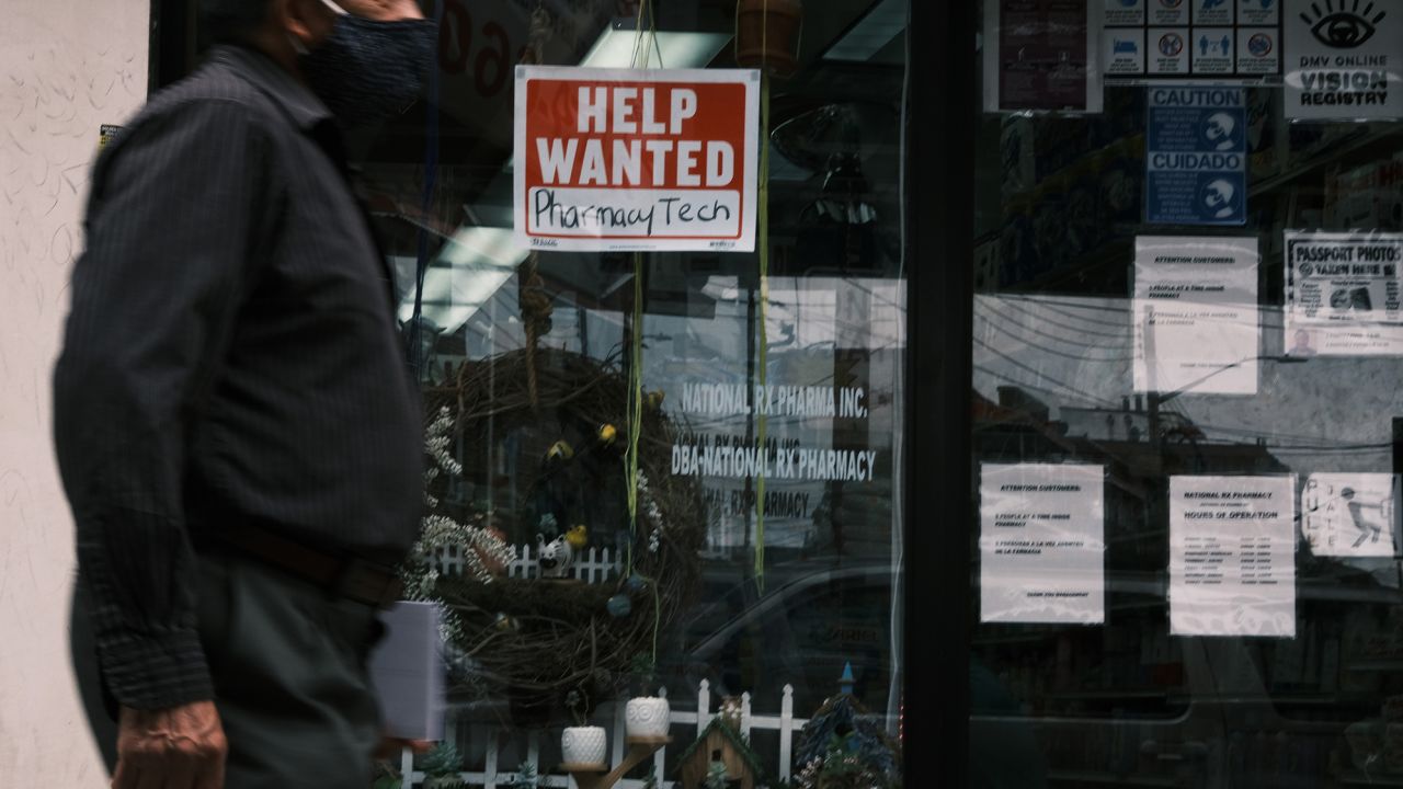 People walk by a Help Wanted sign in the Queens borough of New York City on June 04, 2021 in New York City. 