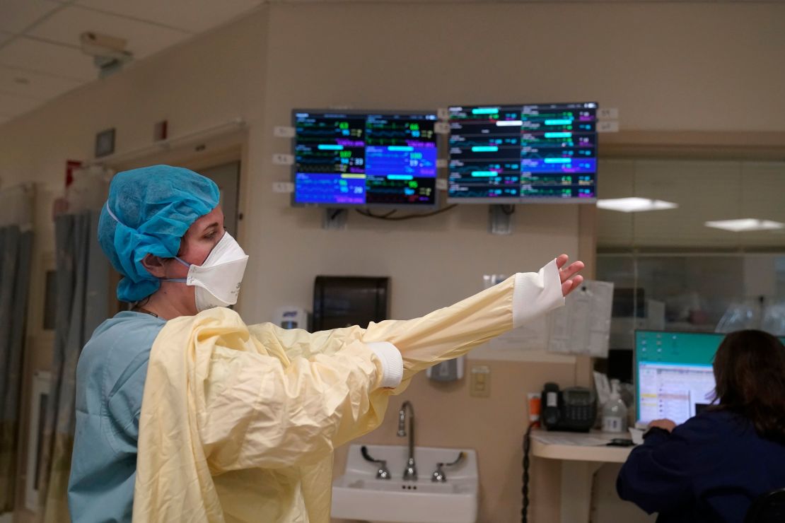 A nurse suits up with protective gear before entering a patient's room January 3 at the Covid-19 ICU at Dartmouth-Hitchcock Medical Center, in Lebanon, New Hampshire.