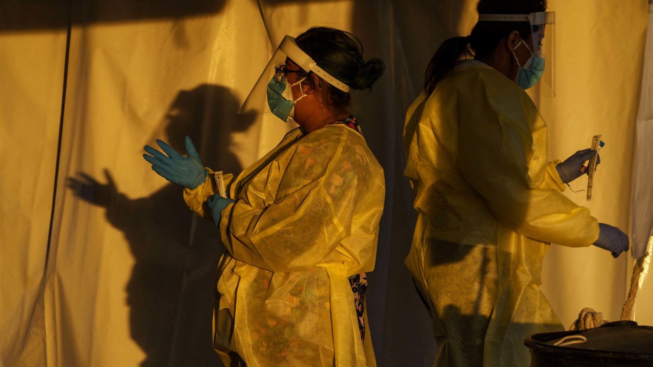 Healthcare workers are pictured at a drive-thru Covid-19 testing site in El Paso, Texas on January 12, 2022. - The country is currently seeing an average of 750,000 cases a day -- though that figure is soon expected to exceed a million -- around 150,000 total Covid hospitalizations, and more than 1,600 daily deaths. (Photo by PAUL RATJE / AFP) (Photo by PAUL RATJE/AFP via Getty Images)