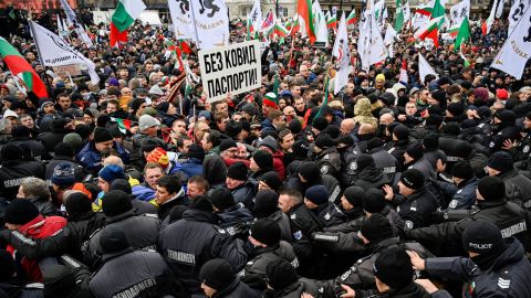 Crowds of protesters push against police cordons as they try to enter Bulgaria's parliament building in Sofia on January 12, 2022.