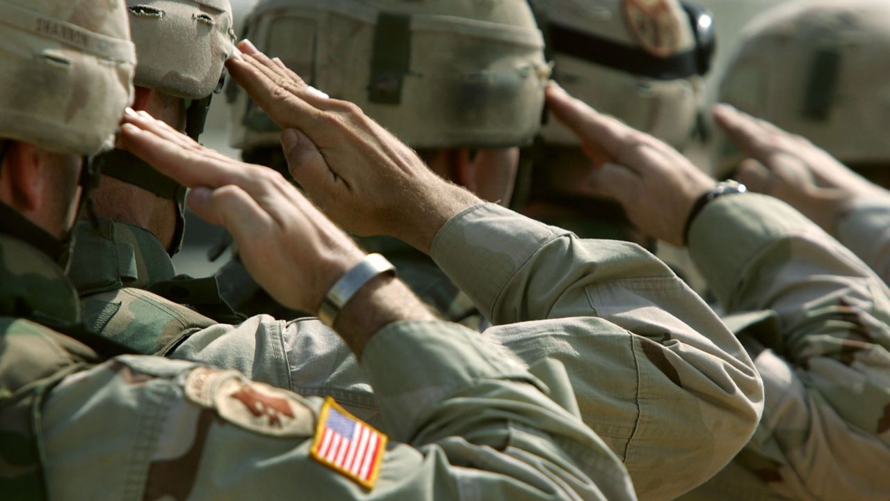 DUJAIL, IRAQ - OCTOBER 18:  U.S. Army soldiers salute during a memorial service for Sgt. Robert Tucker at a military base October 18, 2005 in Dujail, Iraq. Tucker, 20, from Cookeville, Tennessee, was killed by insurgents when a roadside bomb blew up his armored vehicle on October 13 near Dujail, just two weeks before the end of his 10-month deployment in Iraq. He was assigned to K-Troop, of the 278th Armored Cavalry Regiment, which patrols the area around Dujail. Saddam Hussein is scheduled to go on trial on October 19, for the death of 143 people from Dujail who he allegedly ordered killed in 1985 in revenge for an assassination attempt.  (Photo by John Moore/Getty Images)