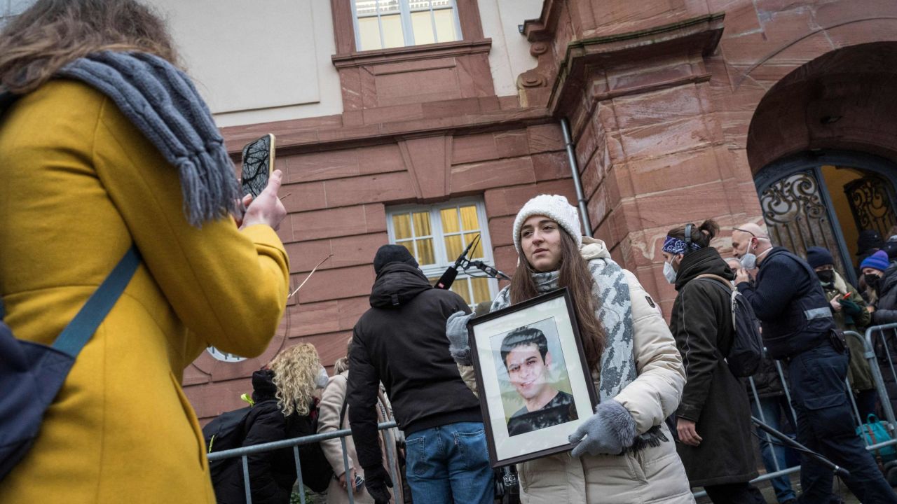 Syrian campaigner Samaa Mahmoud shows a picture of her uncle, Hayan Mahmoud, as she and others wait outside the courthouse in Koblenz, western Germany, on Thursday.