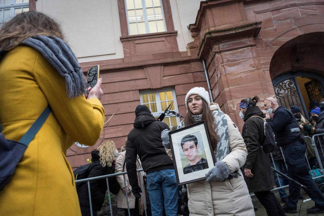 Syrian campaigner Samaa Mahmoud shows a picture of her uncle, Hayan Mahmoud, as she and others wait outside the courthouse in Koblenz, western Germany, on Thursday.