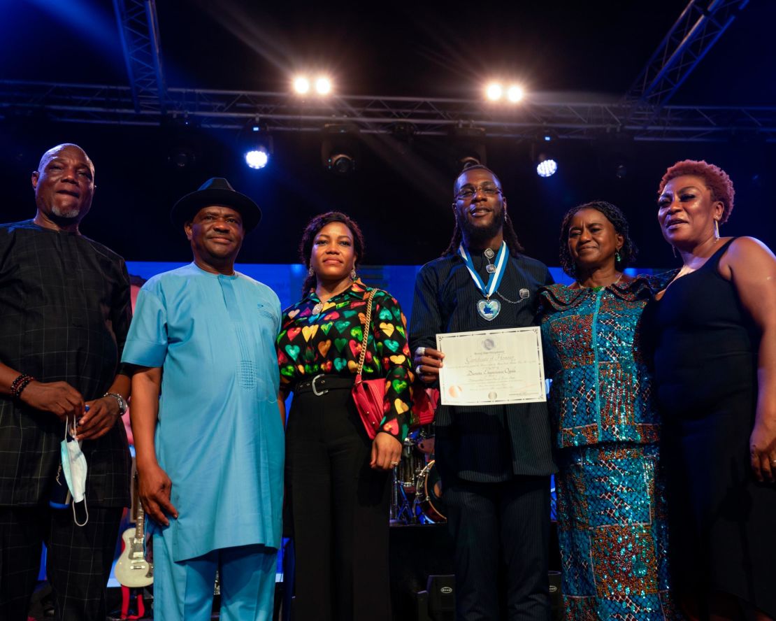 Burna Boy, joined by his father (far left) and mother (far right) received a proclamation from the governor of Rivers State, Nigeria, Ezenwo Nyesom Wike (second from left).