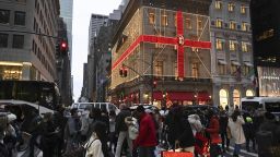 Shoppers walk past the Fifth Avenue entrance to the Cartier Building on December 28, 2021 in New York.