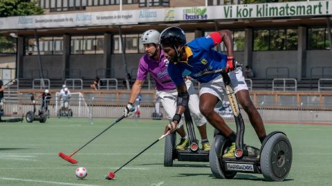 Captain Nevin Roach (in blue) on the attack for Team Barbados at the 2019 Segway Polo World Championships, Sweden.