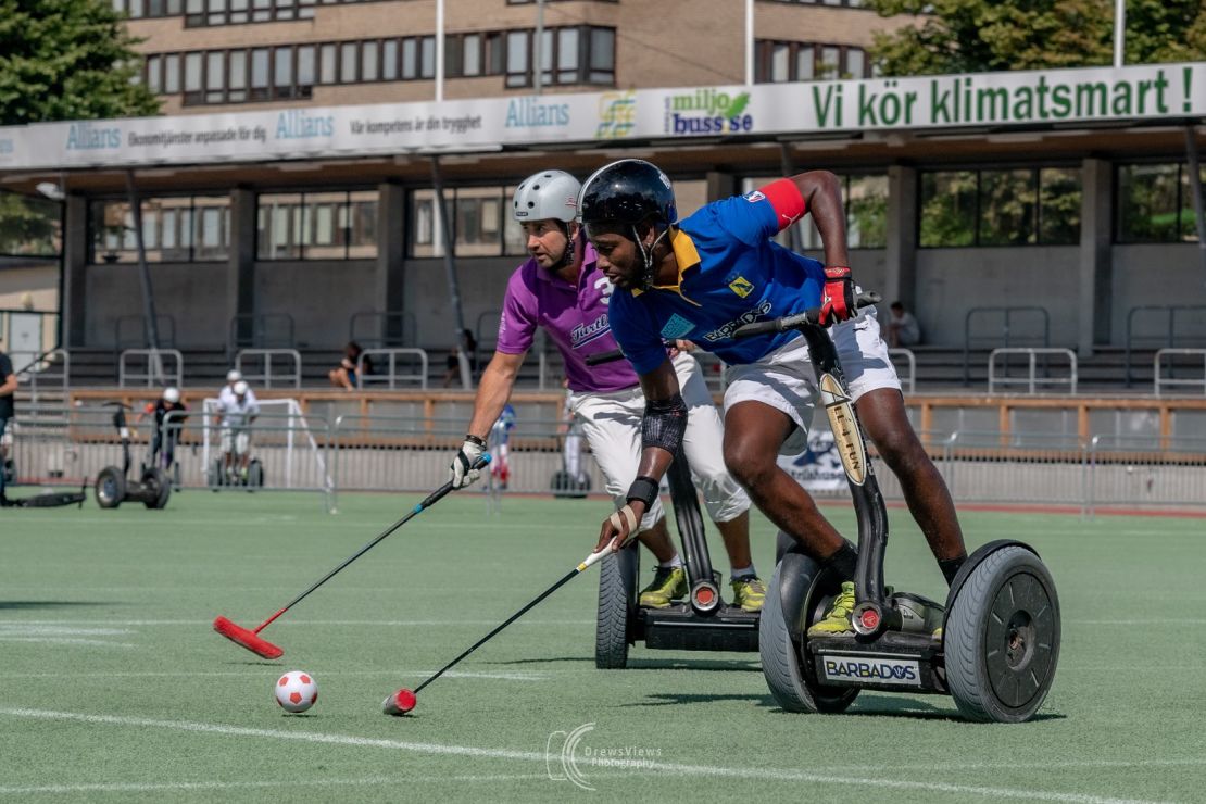 Captain Nevin Roach (in blue) on the attack for Team Barbados at the 2019 Segway Polo World Championships, Sweden.