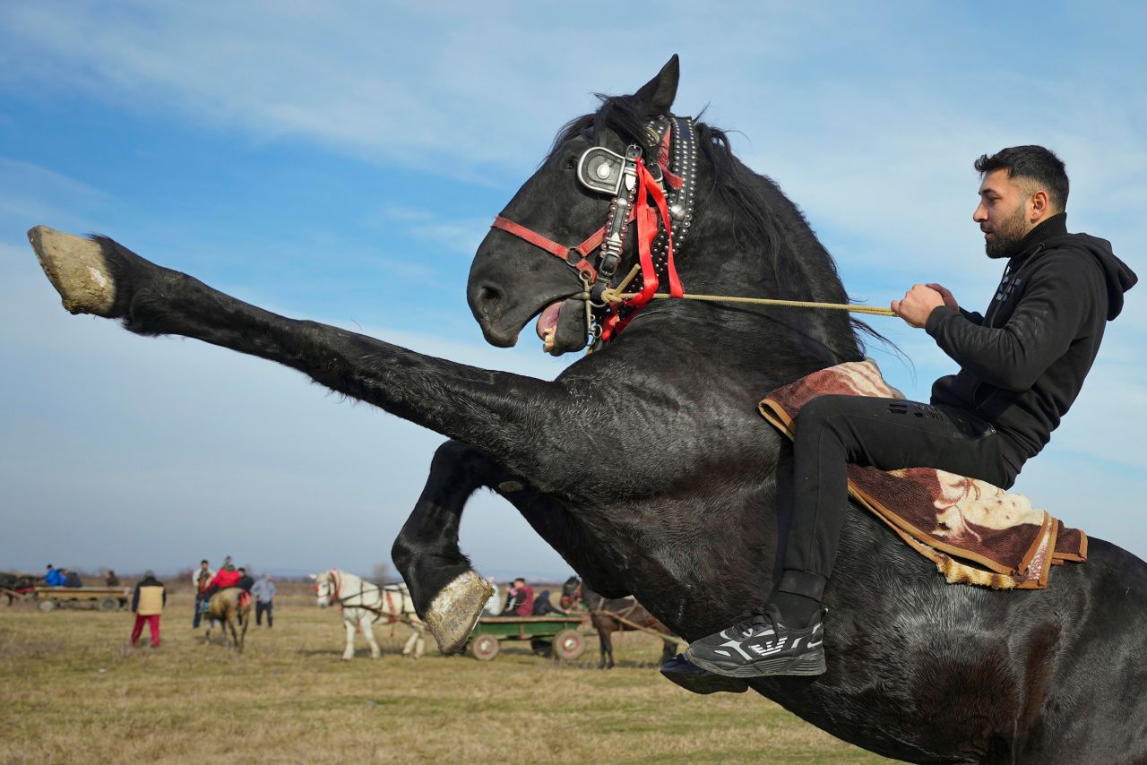A man shows off his riding skills during Epiphany celebrations in Pietrosani, Romania, on Thursday, January 6. Epiphany is a Christian holiday, and villagers in Pietrosani traditionally have their horses blessed with holy water before competing in a race.