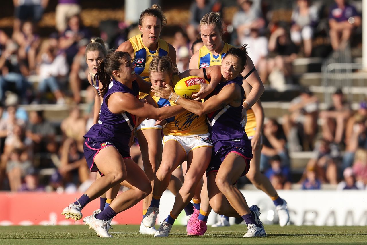 Isabella Lewis, an Australian rules footballer with the West Coast Eagles, is tackled by two Fremantle Dockers during an AFLW match in Perth, Australia, on Saturday, January 8.