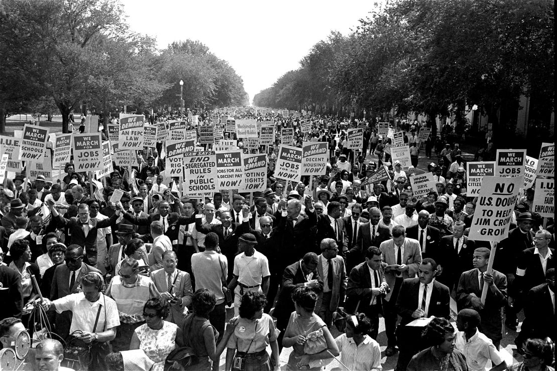 The Rev. Martin Luther King Jr., center with arms raised, marches along Constitution Avenue with other civil rights protesters to the Lincoln Memorial during the March on Washington on August 28, 1963. 