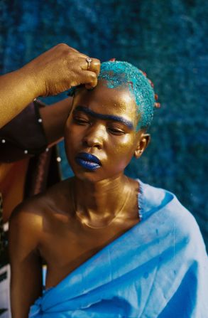 The title, roughly translated, means "Let us go." In Ndebele culture, cutting hair, as seen in this picture, symbolizes rebirth. 