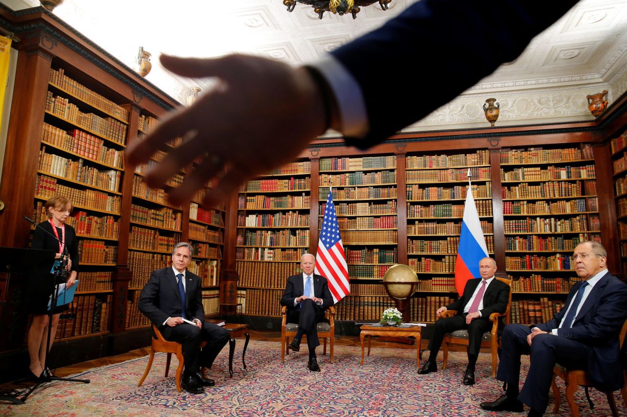 A security officer asks the media to step back at the start of the June 16 summit between Biden and Russian President Vladimir Putin. Seated from left are US Secretary of State Antony Blinken, Biden, Putin and Russian Foreign Minister Sergey Lavrov. <br /><br /><a href="https://www.cnn.com/2021/06/16/politics/president-biden-president-putin-meeting/index.html" target="_blank">The summit,</a> held in Geneva, Switzerland, was the first meeting of Biden and Putin since Biden was elected President.<br /><br />The library room was a tight fit for the presidents, their security teams and about 15 members of the media, Reuters photographer Denis Balibouse said. He tried to get a wide shot to capture the room's atmosphere. "As there was still some disturbance from the media, the Swiss police asked everyone to leave the room, and that's when I noticed the hand of a Russian security officer in front of my lens and I tried to include it in the frame," Balibouse said.<br /><br />After the summit, both presidents described the meeting as generally positive but without any major breakthroughs. There were a few modest outcomes, including an agreement to return each country's ambassador to their post and assigning experts to focus on the growing problem of cyberattacks.