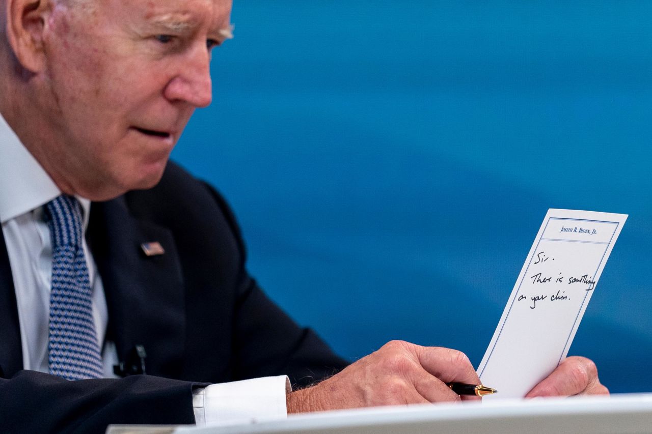 While hosting a virtual meeting with governors on July 30, Biden holds a card that read, "Sir, there is something on your chin." <br /><br />An aide had handed Biden the card earlier in the meeting, and the President was using the other side of it to take notes. <br /><br />"In Washington and with the seat of power, the smallest things can often times become big news, and this photograph of a lighthearted and minor gaffe quickly spread across news and social media," Associated Press photographer Andrew Harnik said.