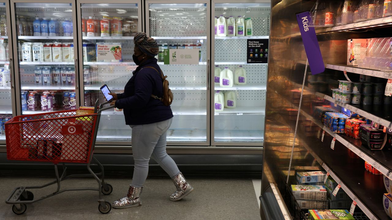 A shopper passes by depleted refrigerated shelves at a Target store January 12 in Springfield, Virginia. 