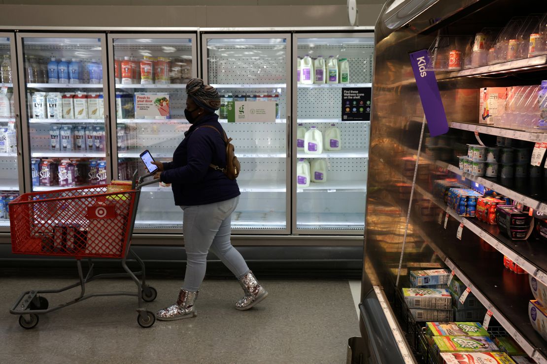 A shopper passes by depleted refrigerated shelves at a Target store January 12 in Springfield, Virginia. 