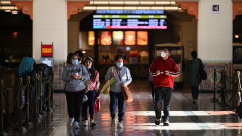 A family wearing face masks walks through Union Station in Los Angeles