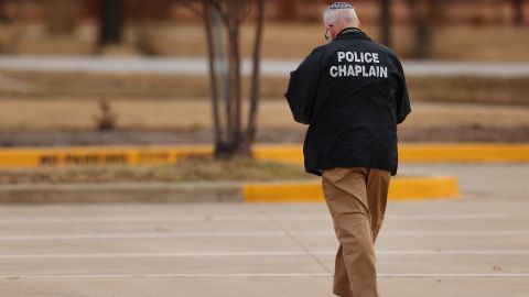 A police chaplain walks near the Congregation Beth Israel synagogue in Colleyville, Texas, on Saturday, January 15, 2022. 