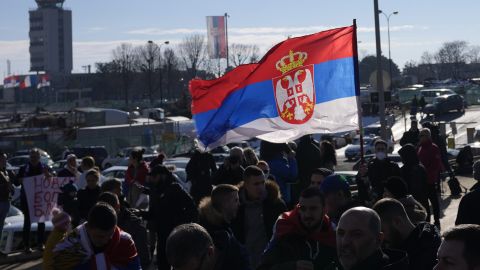 Fans wave a Serbian flag as Djokovic arrives in Belgrade. 