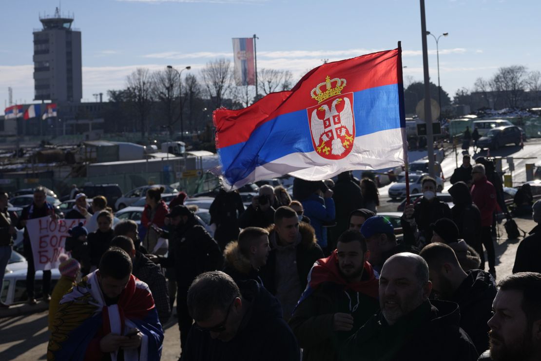 Fans wave a Serbian flag as Serbian tennis player Novak Djokovic arrives at the Nikola Tesla airport in Belgrade, Serbia, on Monday, January 17. 
