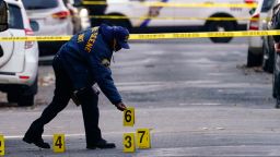 A police officer collects evidence markers at the scene of a shooting in Philadelphia, Wednesday, Dec. 1, 2021. (AP Photo/Matt Rourke)