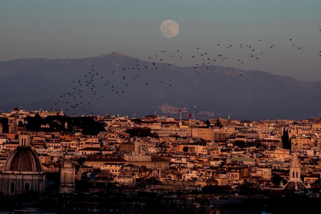 Starlings fly in the sky as full moon rises over the city of Rome, Italy, on January 17.