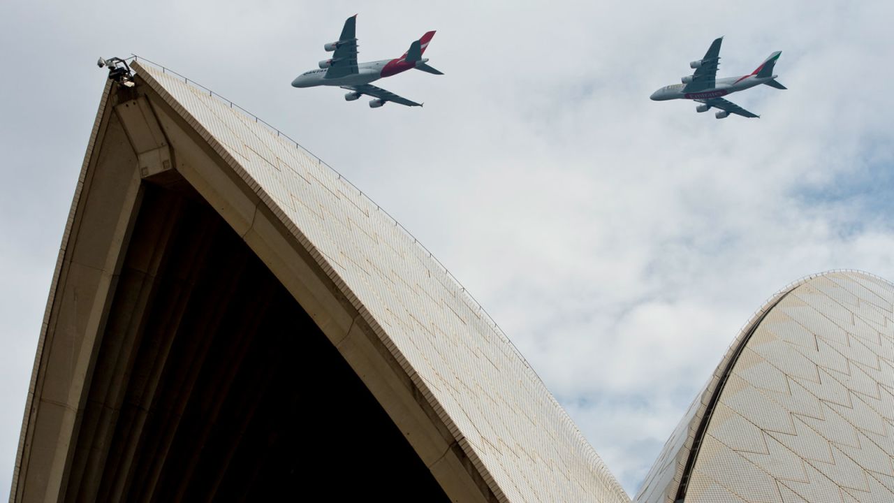 A Qantas Airbus A380 and Emirates Airbus A380 fly over Sydney Harbour on March 31, 2013. 
