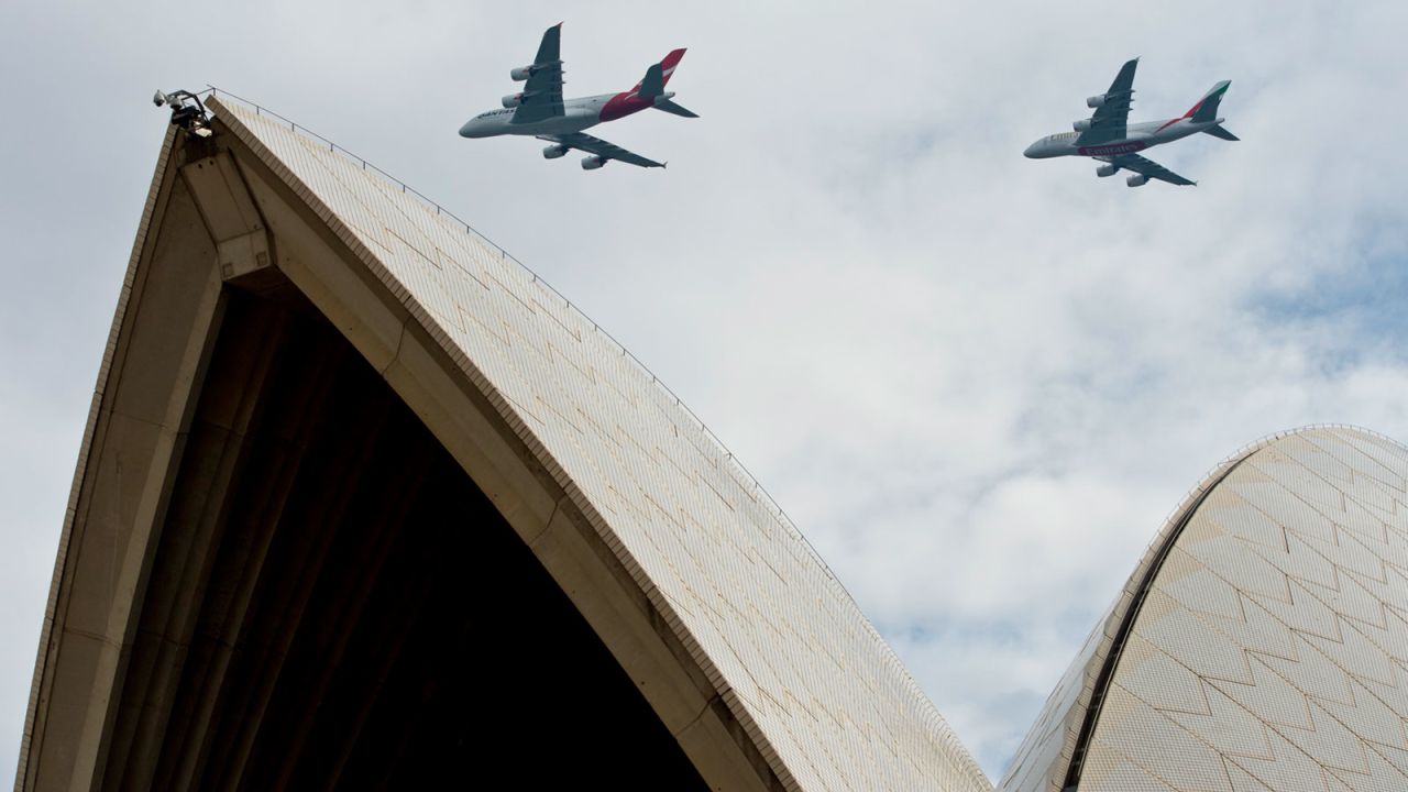 A Qantas Airbus A380 and Emirates Airbus A380 fly over Sydney Harbour on March 31, 2013.