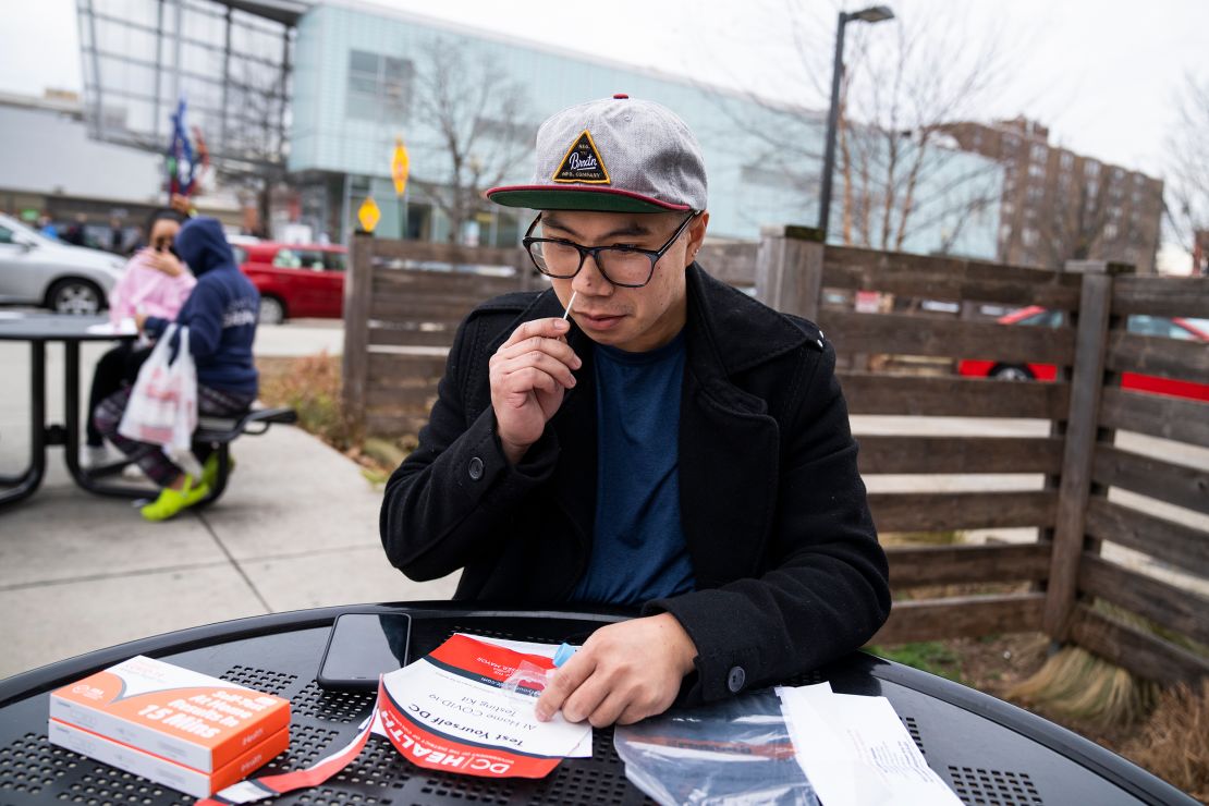 Aaron Salvador swabs his nose with a coronavirus rapid antigen test kit in Washington, DC, on December 29, 2021.