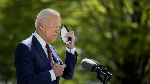 President Joe Biden removes his mask before speaking at the White House on April 27, 2021.