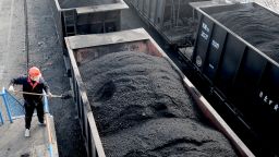 A worker shovels coal onto a freight train at a coal mine of Huaibei Coal Mine Inc. on January 12, 2022 in Huaibei, Anhui Province of China. 