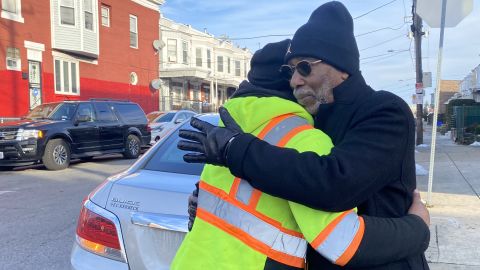 Larry Miller hugs Tyrone Kegler, great nephew of Edward White, at the same intersection where Miller committed murder. 