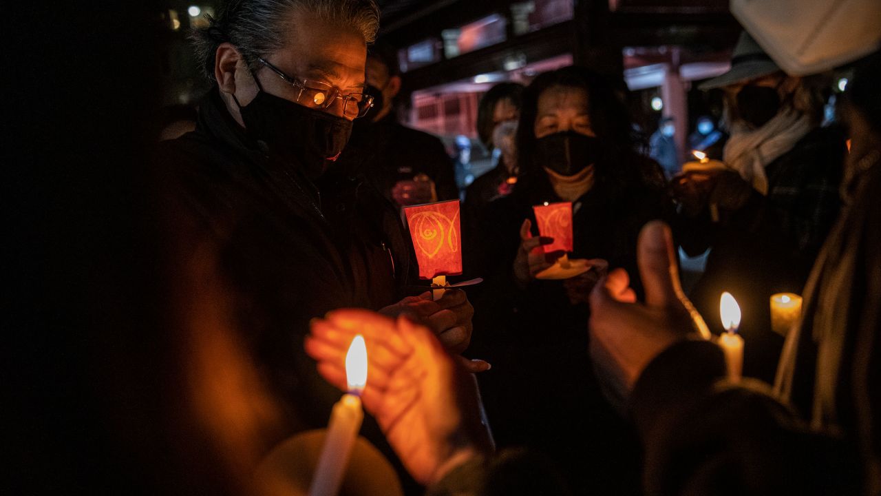 Philip Lai, left, of South San Francisco, at a candlelight vigil for Michelle Alyssa Go at Portsmouth Square in San Francisco.