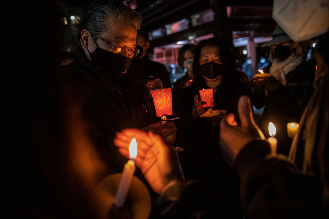 Philip Lai, left, of South San Francisco, at a candlelight vigil for Michelle Alyssa Go at Portsmouth Square in San Francisco.