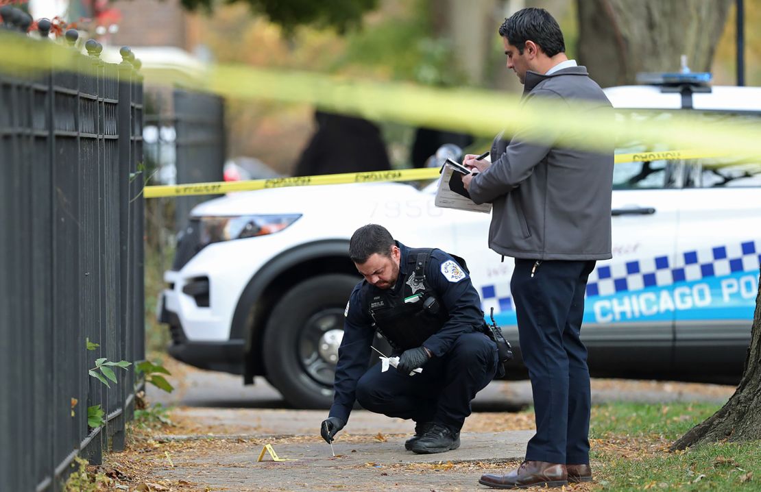 A Chicago police officer investigates a fatal shooting in the Hyde Park neighborhood in November 2021.