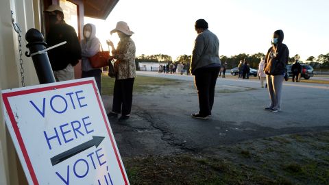 Voters stand in line to cast their ballots during the first day of early voting in the US Senate runoff election on December 14, 2020, at the Gwinnett Fairgrounds outside Atlanta.