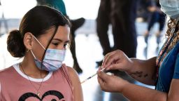 A girl receives a dose of the Pfizer-BioNTech vaccine against Covid-19, at a vaccination post inside the Children's Museum, in San Jose, Costa Rica, on January 12, 2022. (Photo by Ezequiel BECERRA / AFP) (Photo by EZEQUIEL BECERRA/AFP via Getty Images)