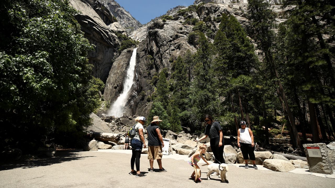 YOSEMITE NATIONAL PARK, CALIFORNIA - JUNE 11: Visitors admire Yosemite Falls on June 11, 2020 in Yosemite National Park, California. . Yosemite National Park reopened today with many restrictions after shutting down in March to protect people from COVID-19. Only about half of the average June visitors will be allowed in, and they must make an online reservation for each car. The park will issue 1,700 day passes each day and an additional 1,900 passes for reservations at campsites or hotels in the park. (Photo by Ezra Shaw/Getty Images)