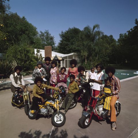 Janet Jackson, right in a yellow dress, sits with her brother, Jermaine Jackson, and other members of their family beside the pool at their parents' home in Encino, California, in 1971. 