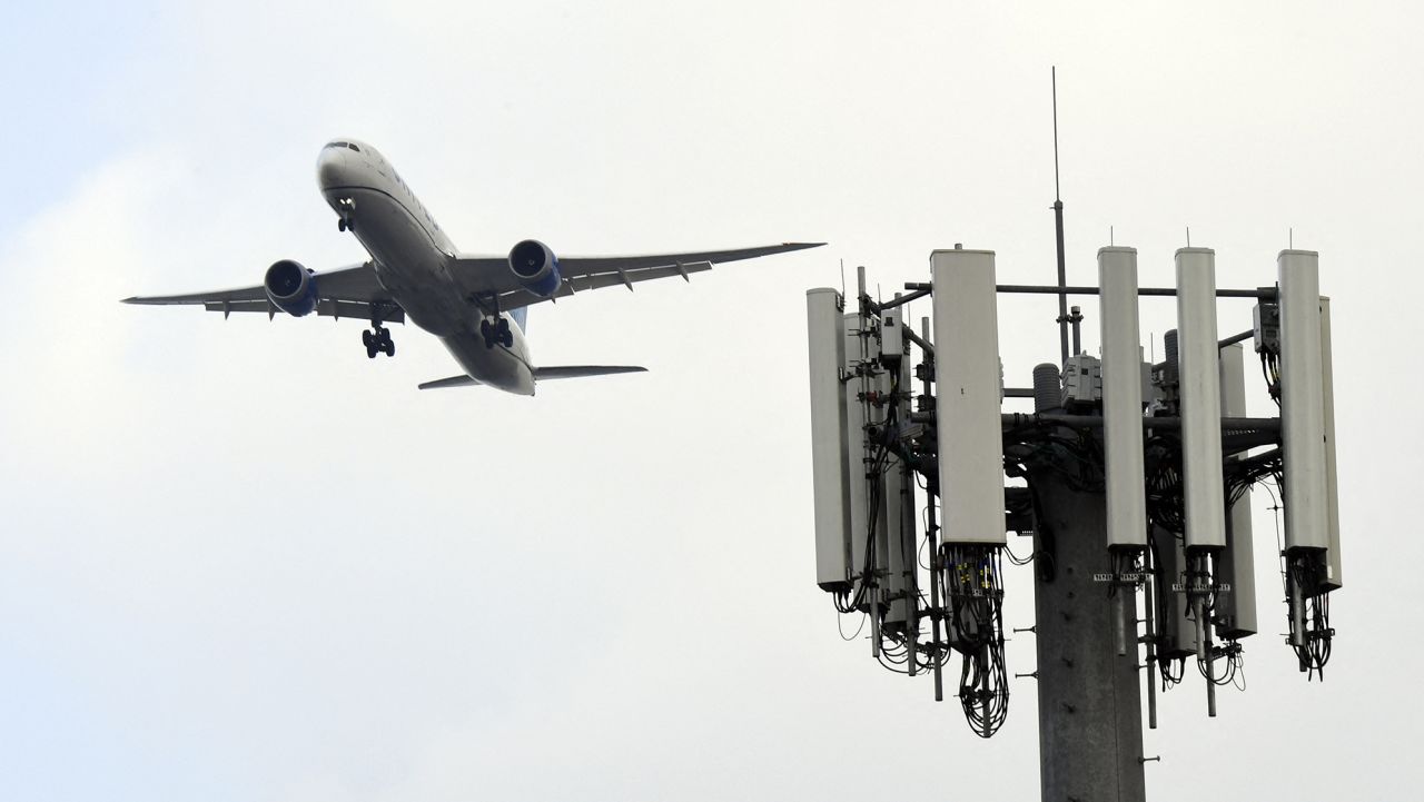 A cellular tower stands as a United Airlines Boeing 787 Dreamliner airplane lands at Los Angeles International Airport (LAX) in the Lennox neighborhood of Los Angeles, California on January 19, 2022.