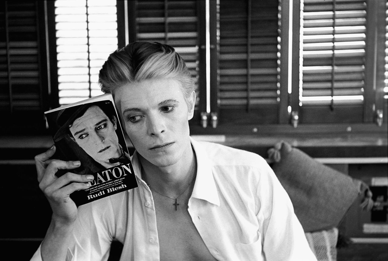 Singer David Bowie holds up a biography of actor Buster Keaton in 1975. "He found out that I had photographed Buster Keaton and Keaton was one of his heroes, so we immediately became friends," <a href="https://www.anothermag.com/art-photography/8840/david-bowie-and-buster-keaton-by-steve-schapiro" target="_blank" target="_blank">Schapiro recalled in 2016.</a> Schapiro shot a couple of album covers for Bowie.