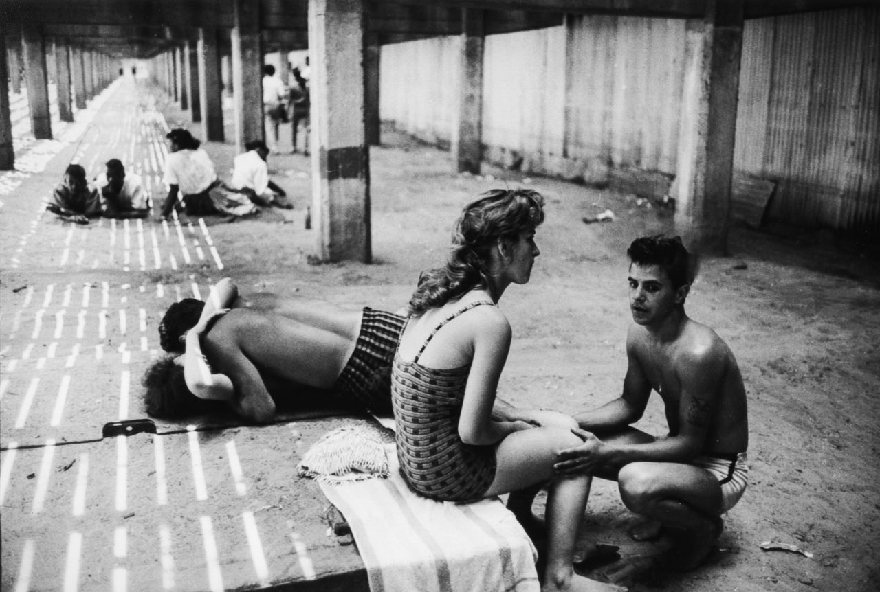 Couples are seen under the Coney Island Boardwalk in New York in 1961.