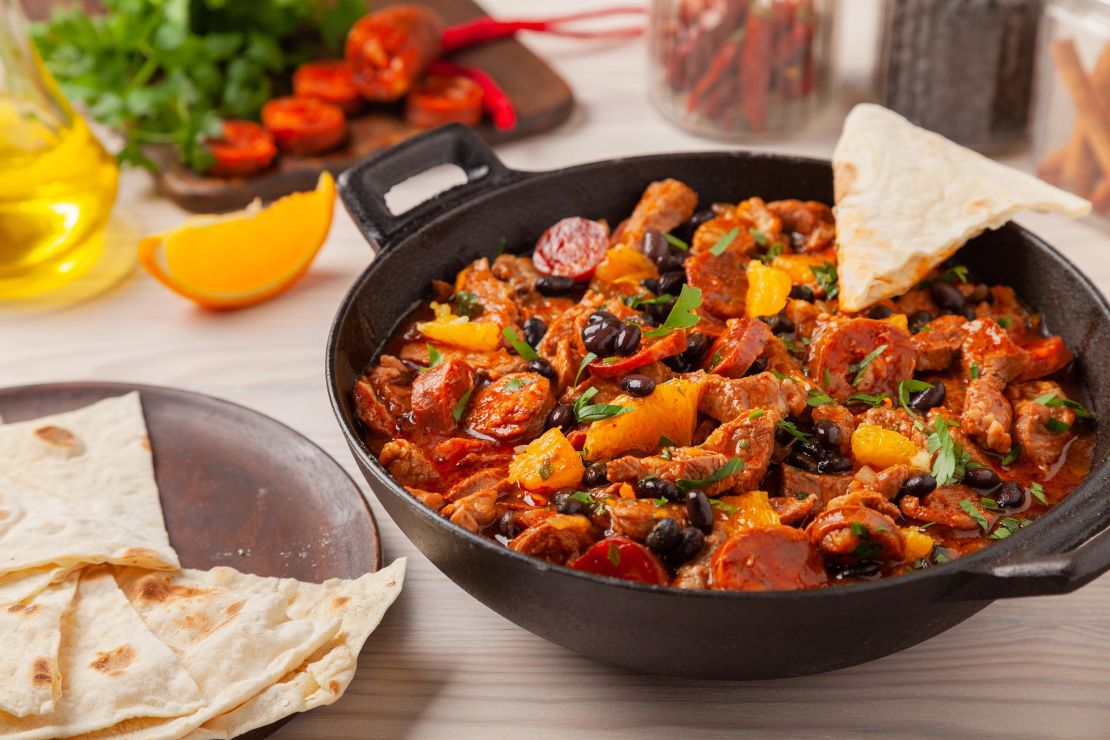 This spicy pork stew with chorizo and black beans is perfect served with tortillas and orange slices.