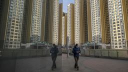 A pedestrian walks past apartment buildings at China Evergrande Group's City Plaza development in Beijing, China, on Friday, Dec. 10, 2021. 