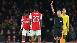 Referee Martin Atkinson (2nd R) shows a red card to Arsenal's Ghanaian midfielder Thomas Partey during the English League Cup semi-final second leg football match between Arsenal and Liverpool at the Emirates Stadium, in London on January 20, 2022. - Liverpool won the game 2-0.  - RESTRICTED TO EDITORIAL USE. No use with unauthorized audio, video, data, fixture lists, club/league logos or 'live' services. Online in-match use limited to 120 images. An additional 40 images may be used in extra time. No video emulation. Social media in-match use limited to 120 images. An additional 40 images may be used in extra time. No use in betting publications, games or single club/league/player publications. (Photo by JUSTIN TALLIS / AFP) / RESTRICTED TO EDITORIAL USE. No use with unauthorized audio, video, data, fixture lists, club/league logos or 'live' services. Online in-match use limited to 120 images. An additional 40 images may be used in extra time. No video emulation. Social media in-match use limited to 120 images. An additional 40 images may be used in extra time. No use in betting publications, games or single club/league/player publications. / RESTRICTED TO EDITORIAL USE. No use with unauthorized audio, video, data, fixture lists, club/league logos or 'live' services. Online in-match use limited to 120 images. An additional 40 images may be used in extra time. No video emulation. Social media in-match use limited to 120 images. An additional 40 images may be used in extra time. No use in betting publications, games or single club/league/player publications. (Photo by JUSTIN TALLIS/AFP via Getty Images)