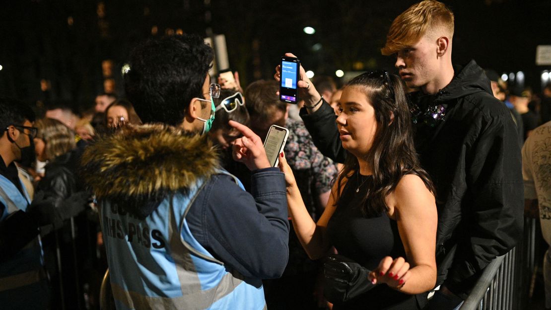 Ravers queue to have their Covid-19 status checked before being allowed to enter Depot Mayfield, a 10,000-capacity club in Manchester, northwest England on New Year's Eve.